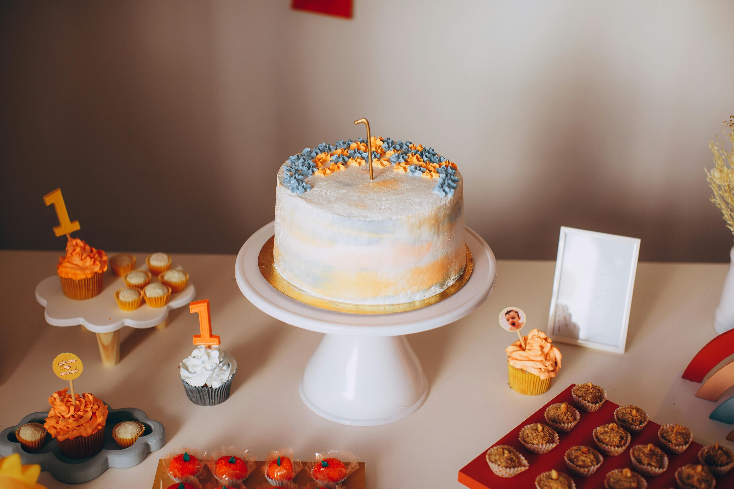Colorful first birthday cake setup with cupcakes, perfect for celebrations and events.
